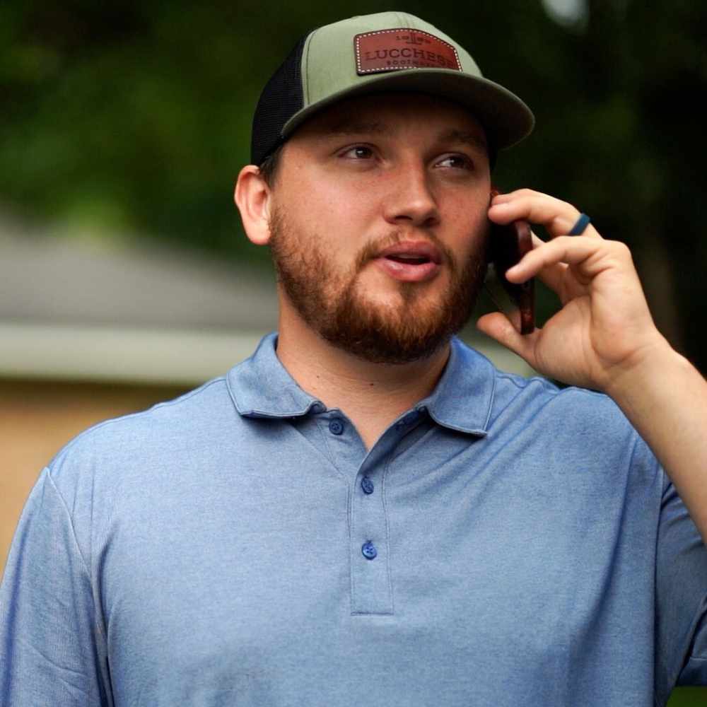 a project manager from metal roof mobile al on the phone with a flat roof and siding customer