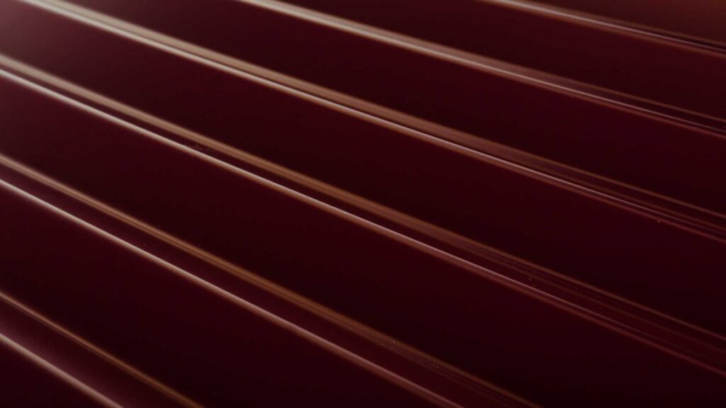 a close up of red metal roof panel on a home's roof