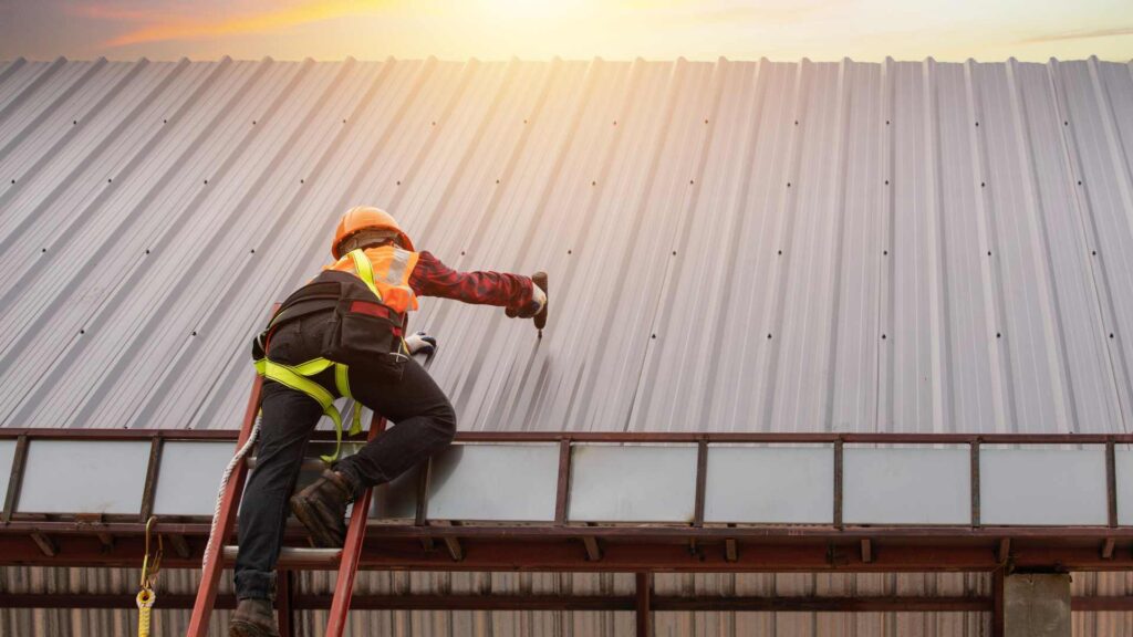 a roofer working on a commercial metal roof in mobile alabama